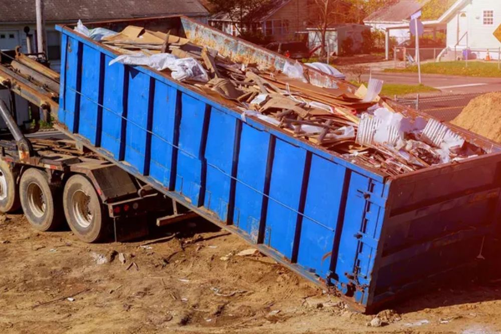A dump truck stands in front of a house, showcasing construction and renovation services in Los Angeles, CA.