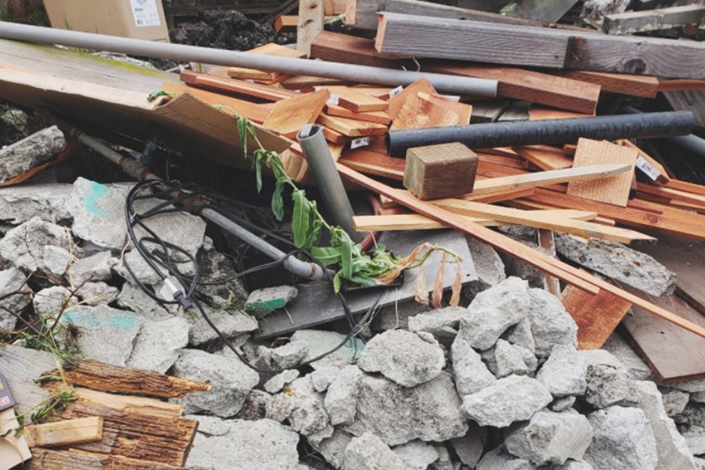 A heap of rubble and wood with assorted tools, symbolizing demolition services offered in Los Angeles, CA.